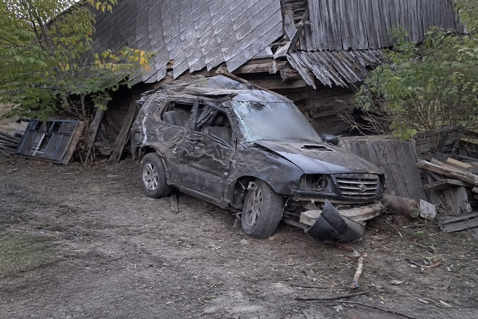 Autoturism distrus prăbușit lângă o casă